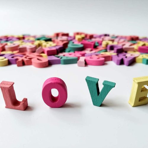 Children's colored letters placed on a white background.